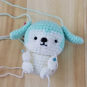attaching limbs and ears of amigurumi puppy