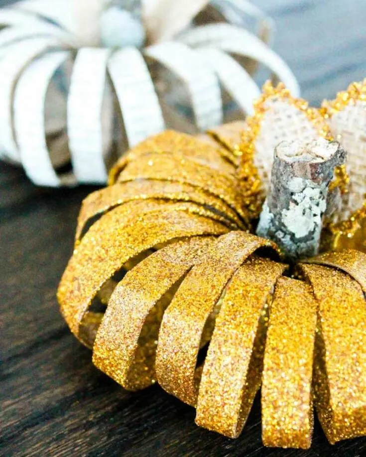 Get into the fall spirit with these festive toilet paper roll pumpkins! Paint the rolls with Mod Podge and add a layer of gold glitter for a cute, shimmery decoration that is perfect for Halloween or Thanksgiving.