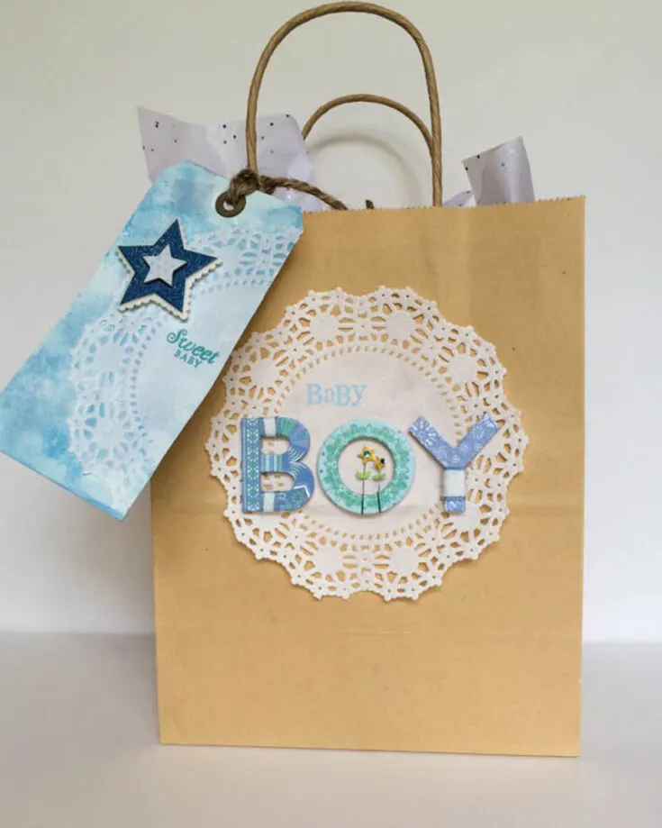 Craft baby boy shower gift bags with the charming touch of doilies and a cute bag tag all to make the new mom feel special. These sweet details add a lovely touch, making your thoughtful gesture all the more memorable!
