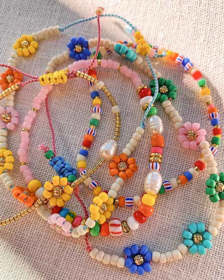 Daisies often symbolize friendships and the joys of childhood wonder. Add a touch of nostalgia to your accessories with these brightly colored beaded daisy chain bracelets.