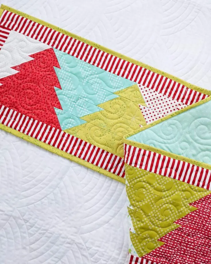 Though Christmas is still ahead, you can always prepare early decor with this fast quilt project! This Christmas tree runner features adorable reversible trees that, when looking at it from either side. It's a stash-buster project. Table runner size: 64" x 12"
