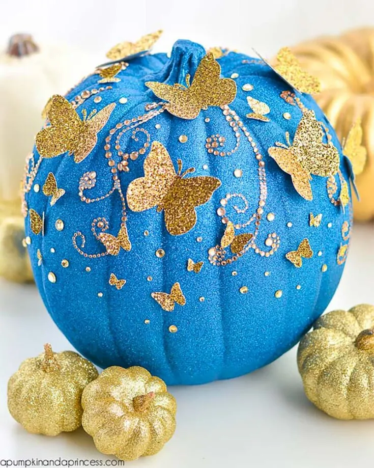 Here's another one of the cute pumpkin painting ideas we have for you. This DIY Cinderella butterfly pumpkin is embellished with gold glitter butterflies, perfect for a magical fall night.