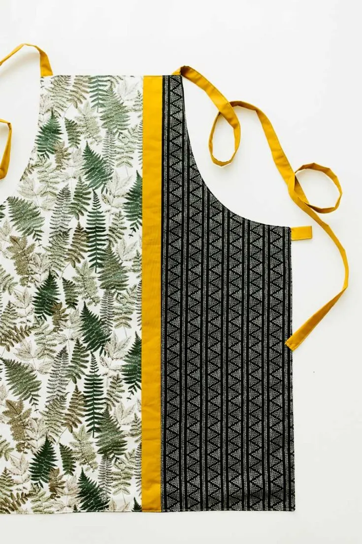 This chic and modern block free apron pattern with adjustable neck straps requires 4 fabrics with varying designs and is great for sewing beginners!