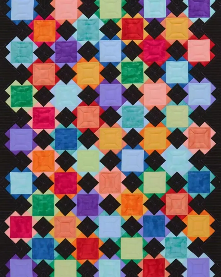 Quilt this delightful project that promises a pop of color to your home decor! This 42 &frac12;" x 59 &frac12;" quilt piece is made with contrasting color blocks with a black background to make the 6" square blocks shine. It's an effortless project that everyone must try.&nbsp;