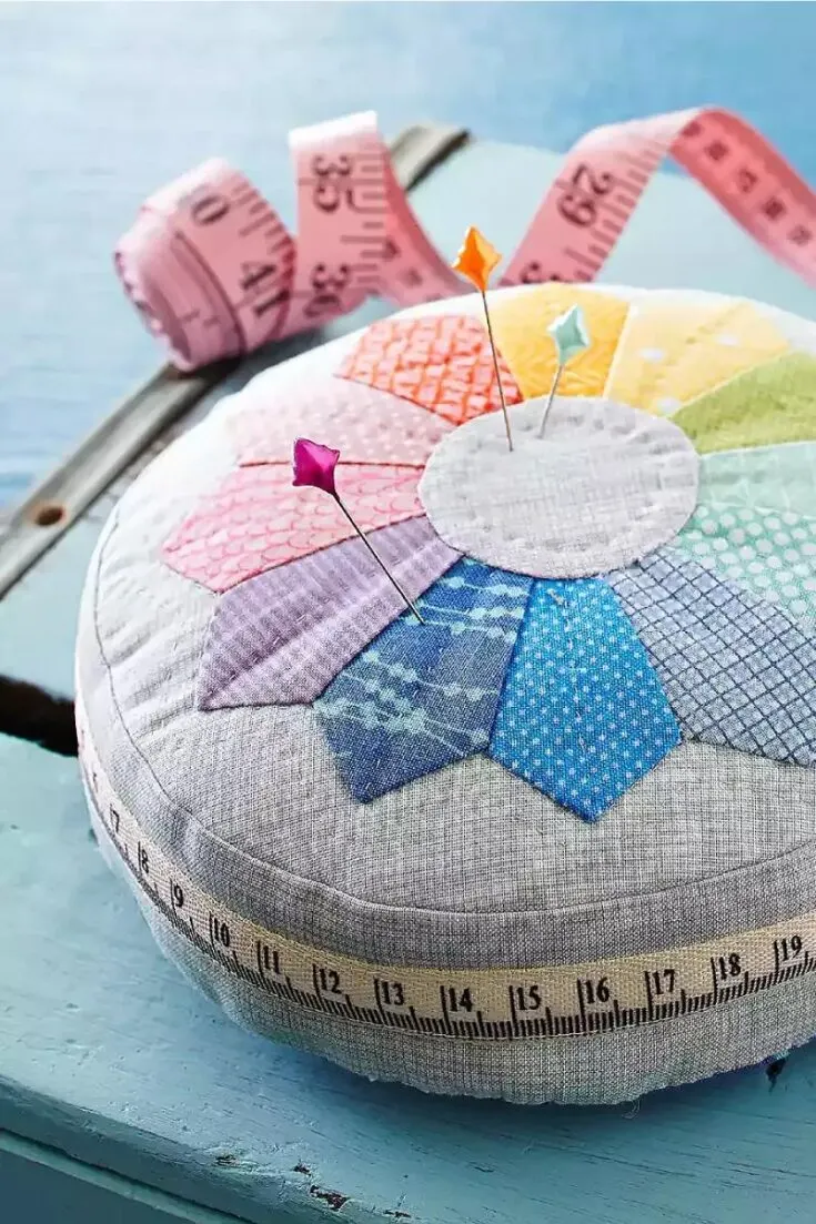 This colorful design uses an appliqu&eacute; technique to form a color wheel that's simple yet pretty. A measuring tape ribbon in the center is a fun and functional detail that completes this pincushion pattern. You could follow the colors of this rainbow or switch it up yourself; either way, try it!