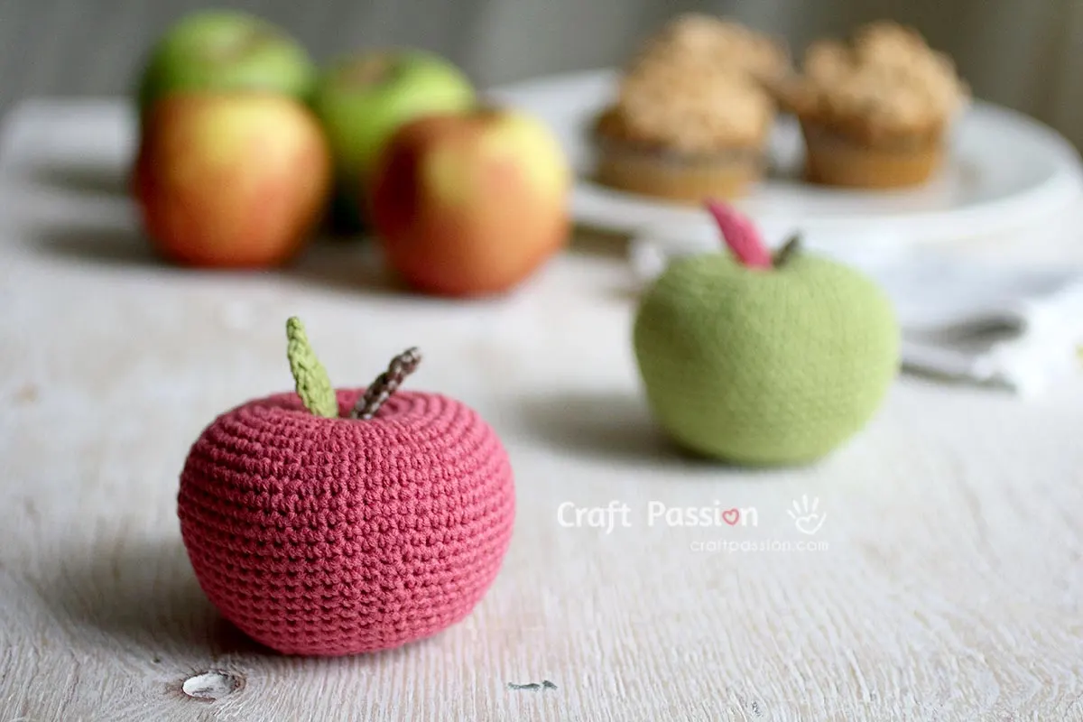 Add some characters to the crochet apple with
1. add a worm with its head sticking out from the apple. 
2. Add eyes and a smiling mouth with a rosy cheek for a kawaii look. 
3. Use rainbow-colored yarn to create a rainbow apple.