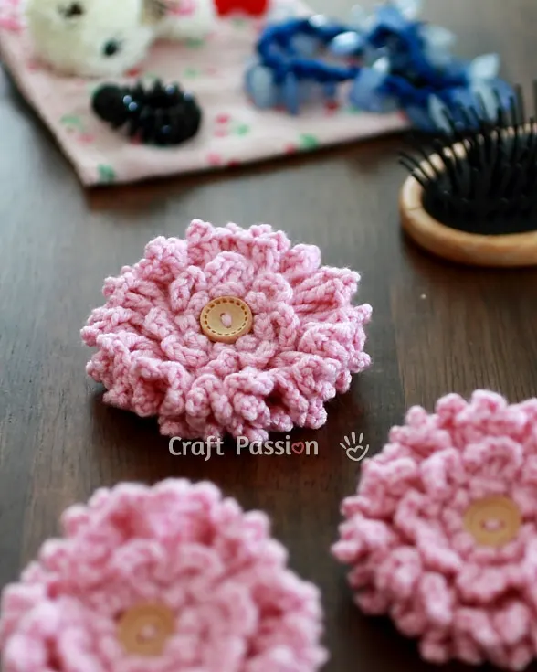 Free pattern to make a beautiful crochet ruffled flower from stashed yarn, perfect as a handmade gift like a brooch or hair tie or embellishment.