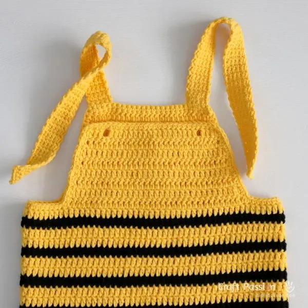 Thread each strap through the small holes on the front bib, then tie them into knots to secure &mdash; this makes the length easily adjustable as your baby grows.
No buttons or snaps needed!