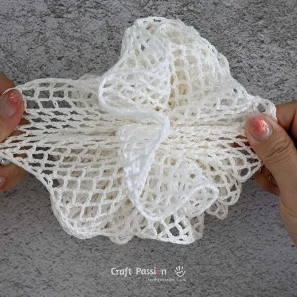 Once cinched, gently tug the layers apart with your fingers to fluff up the loofah.