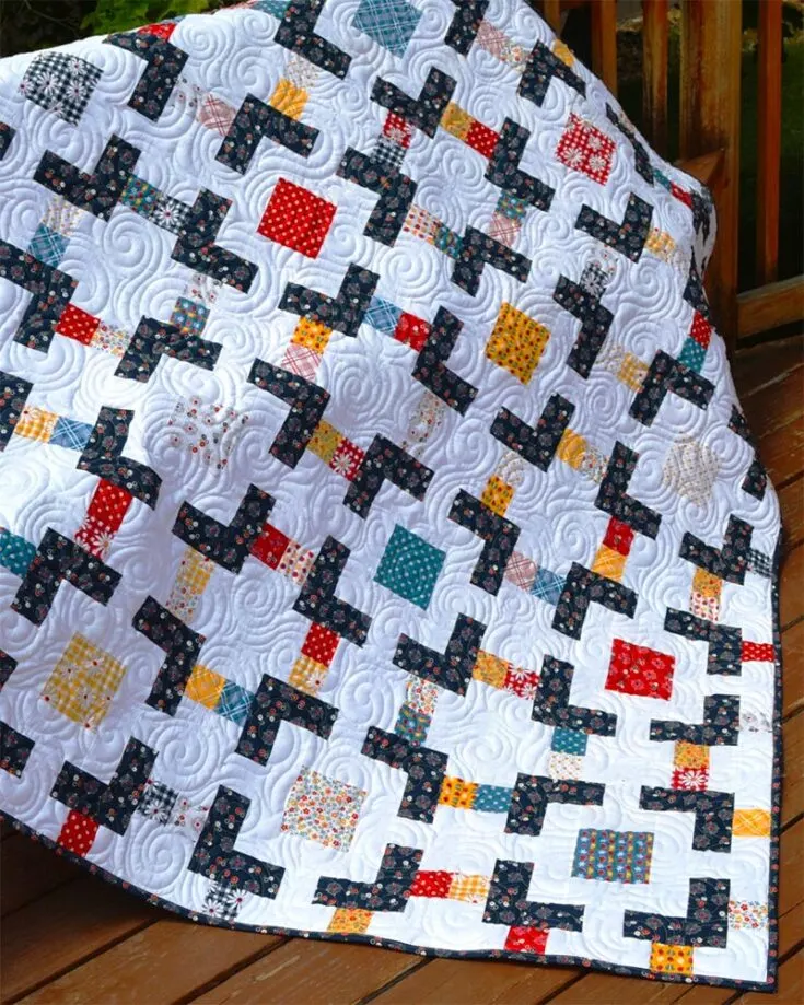 This 64" x 64" quilt from Happy Quilting comprises of gorgeously printed 5" stackers. You'll be cutting up rows of strips to compose this interesting crossroad pattern.