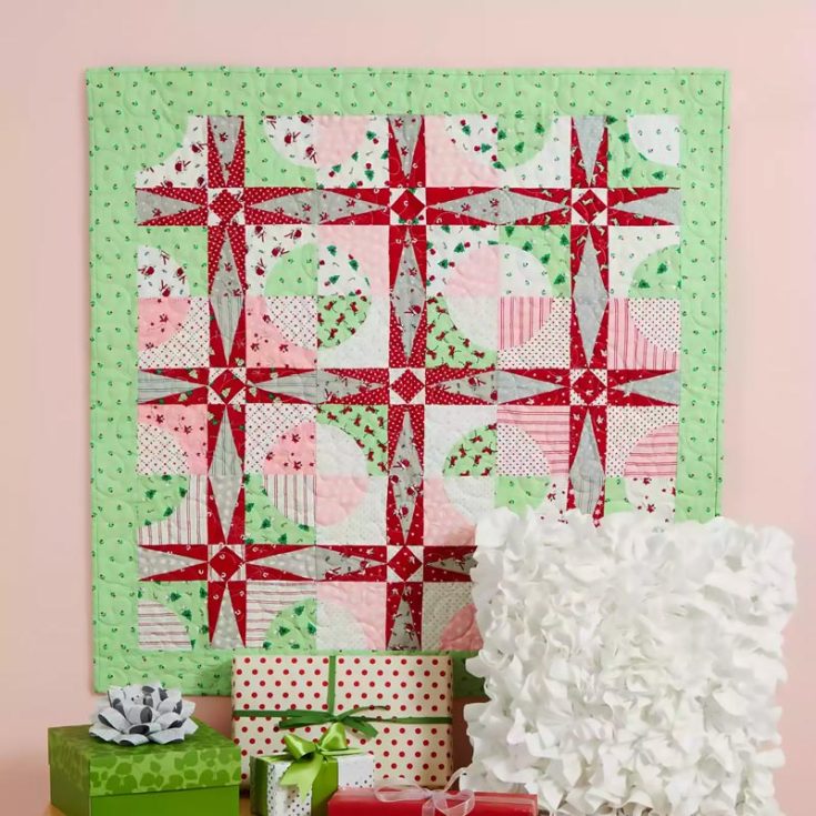 Check out this lovely Christmas-themed quilt design! It's a sharp, pointed seasonal wall hanging that can be doubled as a quilt, and it's made using an assortment of FQ fabric colors, such as green, pink, white, red, and grey, and some green floral fabric for the border and binding. The finished size is 37 &frac12;" x 37 &frac12;".