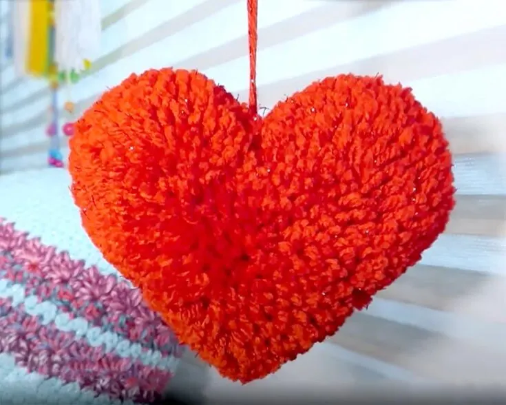 Follow along on this YouTube video to learn how to make a soft and squishy yarn big heart pom pom! It would make a wonderful decoration and a cuddle pillow for your loved ones.