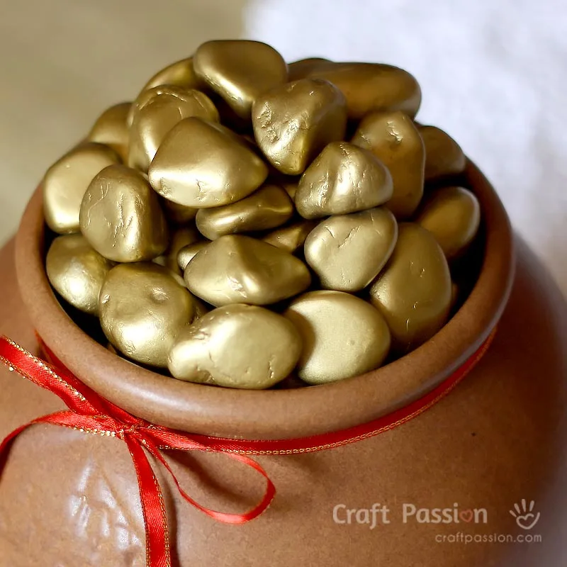 Make this easy faux gold nuggets decor to bring good luck to you. All you need are pebbles and gold spray paint. A pot of gold nuggets is a pot of good luck!