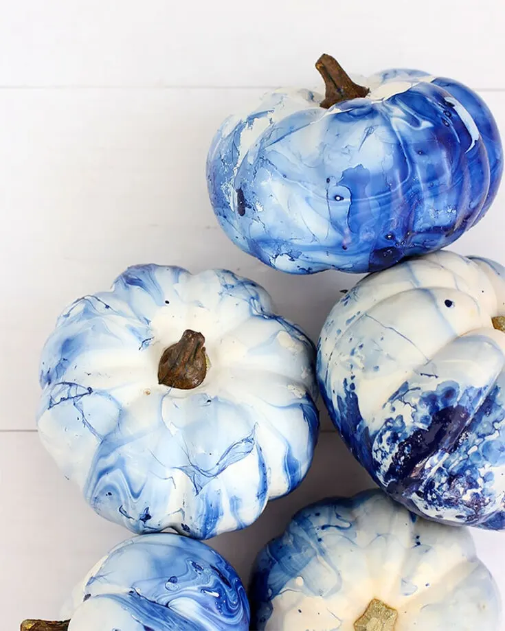 Starting off this list with some mini pumpkin painting ideas. Learn how to make these gorgeous Marbled Indigo Pumpkins using nail polish and water. Since indigo complements white so well, this is one of the best ideas for decorating white pumpkins.
