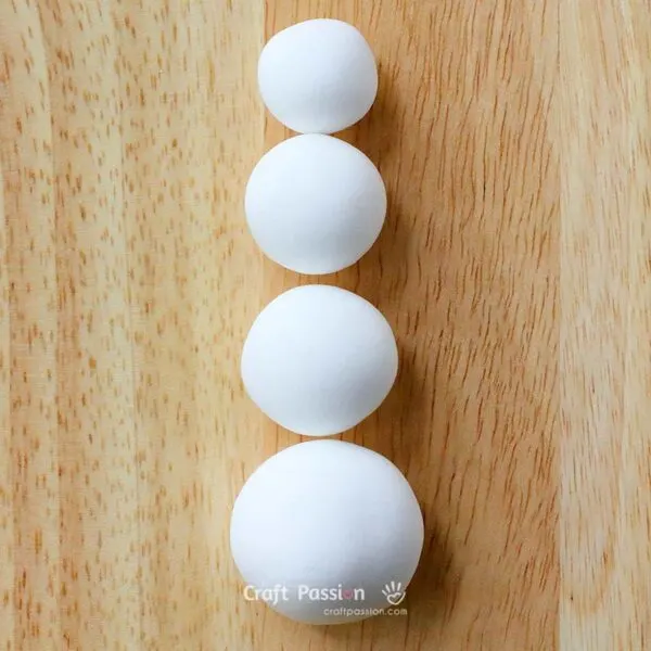 Divide the white clay into four parts: one small, two medium, and one large.
Roll each part into a ball.