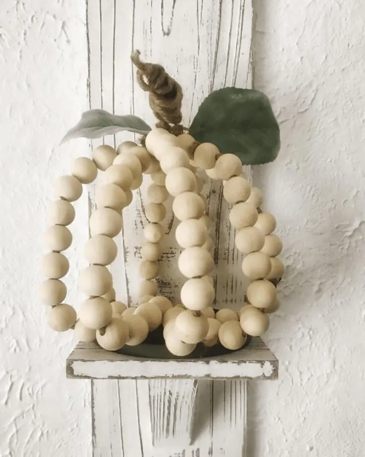 Here's another minimalistic and simple Halloween prop that adds a cute and rustic touch to your living space! It's also super creative to make pumpkins out of wooden beads. Try it out by clicking the link below.