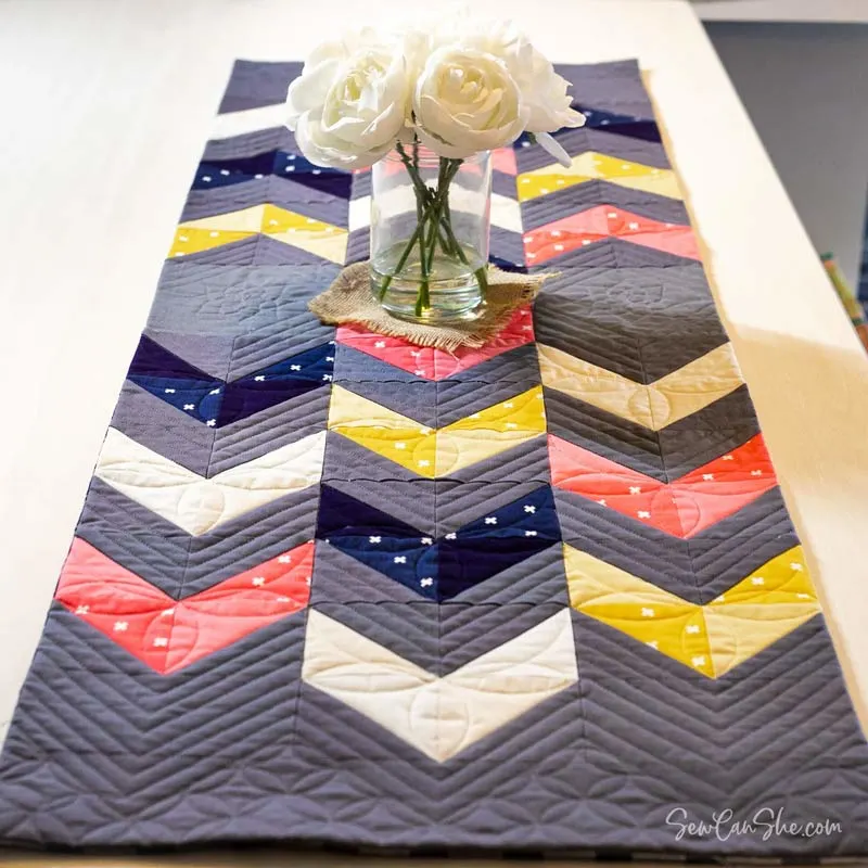 Learn how to make a table runner with this quilt design! It's an easy pattern that features HSTs to form a beautiful and modern striped piece for your table decor. It's a stash-buster project, so this design is ideal if you have any leftover fabric scraps.&nbsp; Table runner size: 18" x 54".&nbsp;