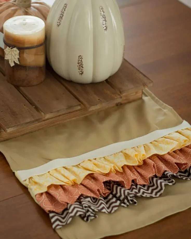 Decorate your tabletop with this easy sew-ruffled runner! It&rsquo;s perfect for fall and features such lovely, warm colors. Fill your table with this fantastic center piece to capture the attention of your guests during every meal.&nbsp; Table runner size: Adjustable