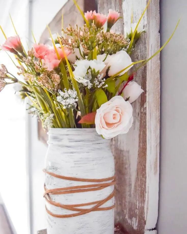 You can never go wrong with a mason jar craft! This farmhouse style mason jar planter is an easy way to add a fresh pop of color in your home. You can opt for fresh flowers instead of faux flowers if that's more to your liking.
