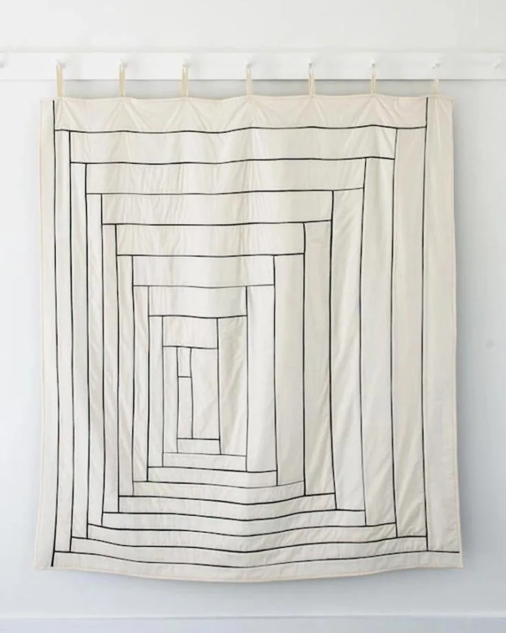 Now, this piece is simply magnificent. If you&rsquo;re a minimalist fan, this fine-line cabin quilt is your calling. Inspired by the minimalist masters of the 20th century, this pattern imitates the thin lines of a graphite-colored pencil, which results in this beauty. The finished size is 54&rdquo; x 60&rdquo;.