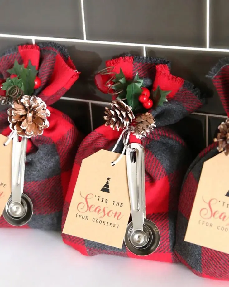 Switch up the traditional treat bag and surprise your guests with a delightful cookie mix tucked inside these cozy flannel cookie mix gift sacks that includes measuring spoons and a festive holiday tag.