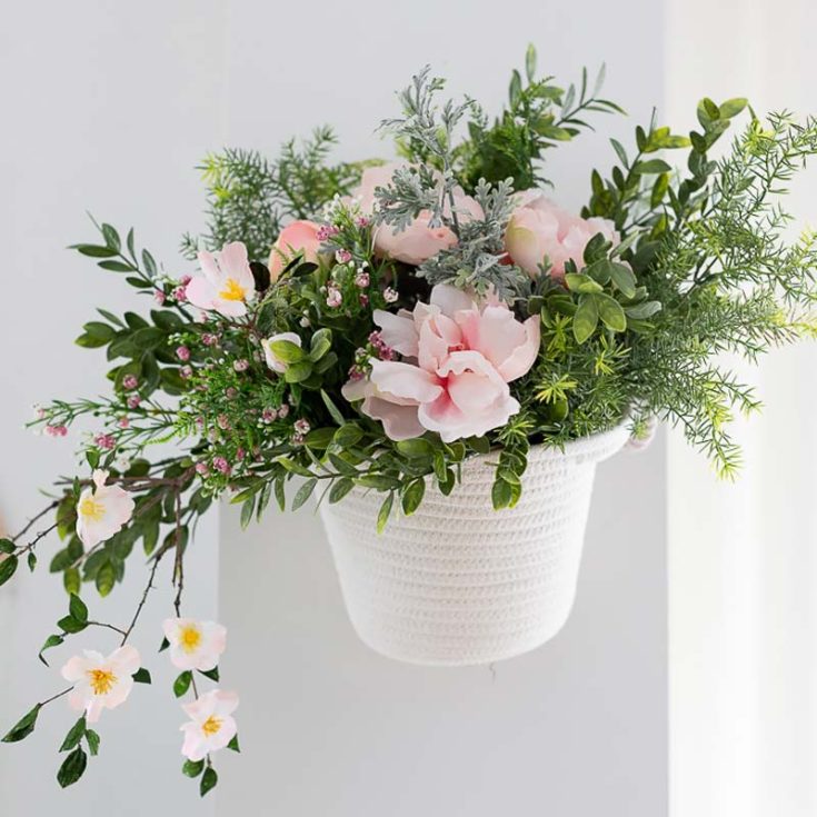 Spring is finally here! Let&rsquo;s welcome spring with this beautiful hanging flower basket complete with pink florals and green leaves you can hang in your living room. You can easily find most of the supplies from the nearest Dollar Tree. As for the crepe blossoms, check out the tutorial by Craftberry Bush.