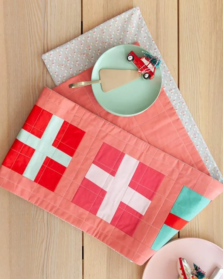 Get into the jolly good season with this table runner idea! It's a modern holiday improv table runner that uses improv-piecing techniques. This design is excellent for the holiday season and adds a quilty vibe to your dining tables.&nbsp; Table runner size: 94" x 14".