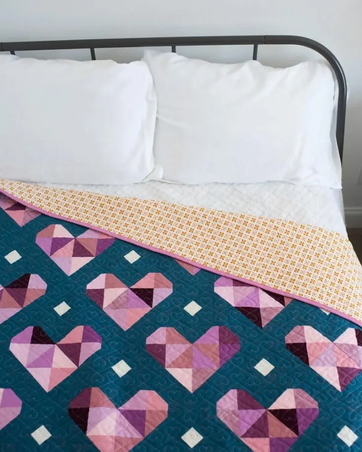 Challenge your quilting skills with unique, intricate heart quilt patterns like this lovely design! The Heart Gems quilt is unlike others, and it&rsquo;s made with geometric shapes that result in clean and sleek hearts. It&rsquo;s a pattern fit for confident beginners and has 5 size options.&nbsp;