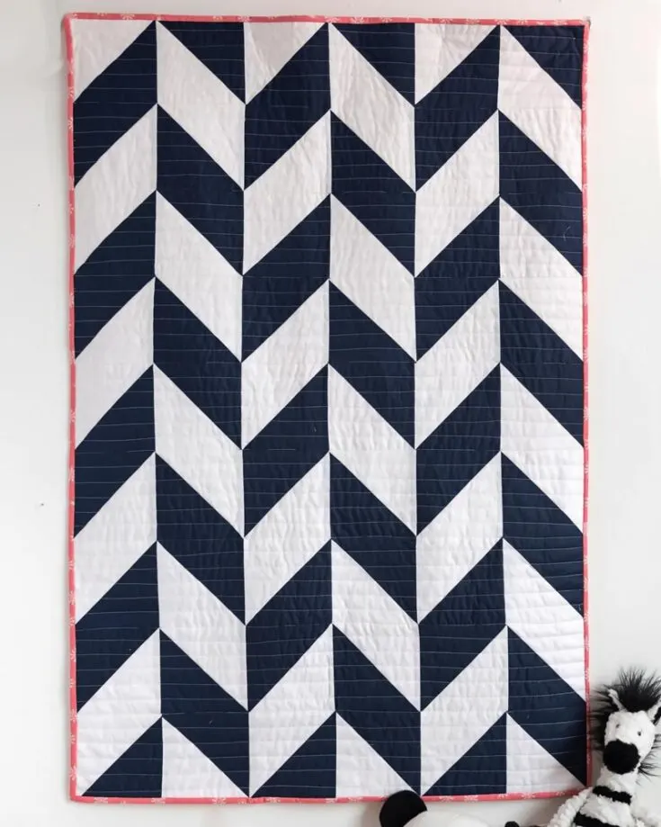 Discover the beauty of this Herringbone Baby Quilt pattern from Polka Dot Chair, where classic design meets modern simplicity! This design features a quick-to-piece 9-at-a-time piecing that uses the simple half-square triangle method, and the final quilt measurements are 36&rdquo; x 54&rdquo;. Learn to quilt it by clicking the link below!