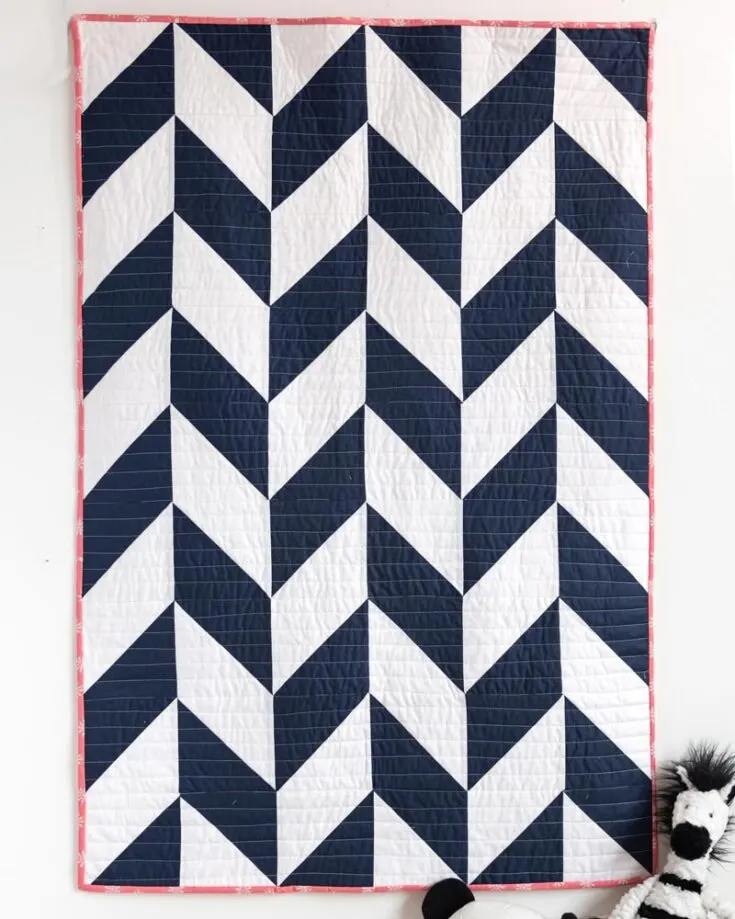 Check out this preppy, stunning, and visually pleasing Herringbone baby quilt pattern that uses 8 at a time HST Method! This pattern has a touch of modern flair to it, making it a fun and stylish way to wrap your little one in warmth and love. The finished size is approximately 36&rdquo; x 54&rdquo;.
