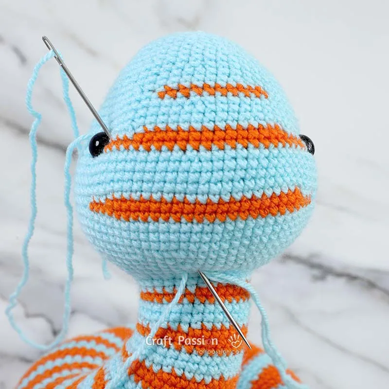 Use a tapestry needle with matching yarn to make stitches behind each safety eye, pulling gently to sink them slightly into the head&mdash;this technique adds depth and brings your crochet snake's personality to life!