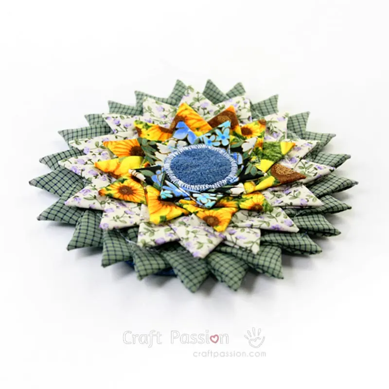 Learn how to sew a sunburst coaster with our sewing tutorial. Adapt this fabric scrap-buster triangle fold coaster method to make a larger rug.