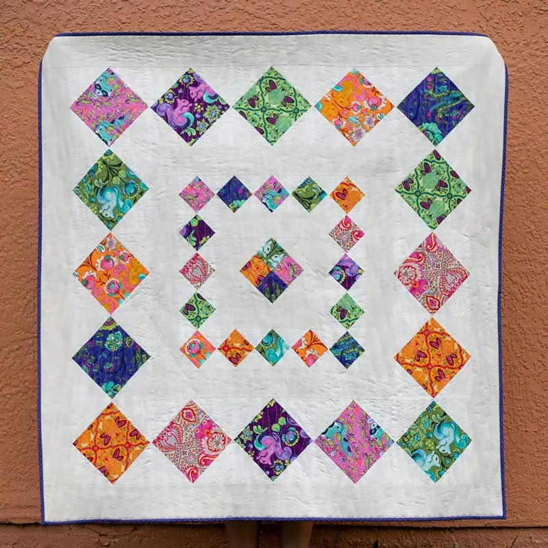 Try quilting this super easy, simple, and fast throw quilt design that is perfect for beginners! It's a medallion pattern and ideal for quilters looking to use large prints because it makes it the main focal point of the quilt with negative spaces surrounding it! The finished dimensions are 54" x 54".&nbsp;