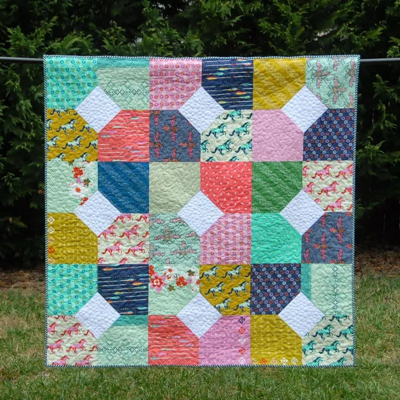 Have a look at this gorgeous quilt called the Layers of Charm! This inviting quilt piece uses the Mustang fabric collection by Melody Miller, which has various colors and prints in the layer cake bundle that give this quilt a fun, scrappy look. The finished size of this quilt measures 57.5&rdquo; x 57.5&rdquo;, resulting in a generous lap-sized quilt. Learn how to make it by clicking the link below to access the tutorial.