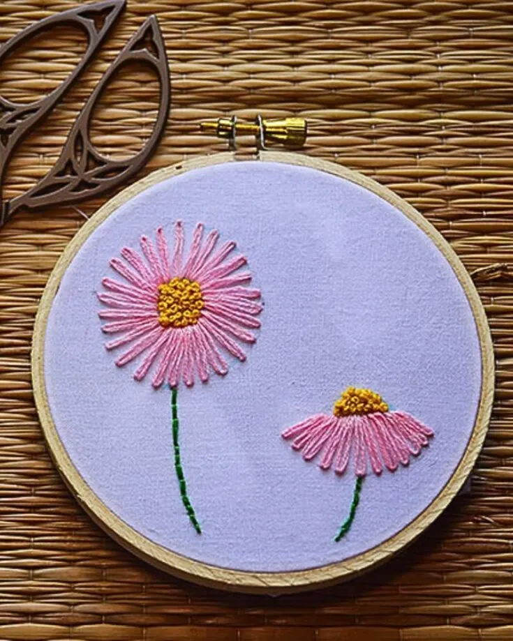 This lazy daisy embroidery stitch is like making small loops to mimic the shape of flower petals. This stitch adds a touch of delicate elegance to your fabric, and it looks beautiful.