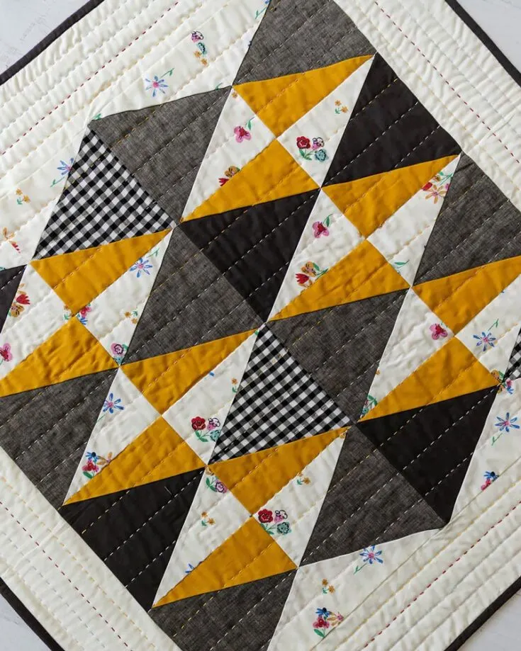 If you're a minimalist girlie looking for a simple design that is bold yet soft, you have got to try out this throw-sized quilt pattern. It's an intermediate-level quilt project because it uses triangle templates provided in the pattern, making this design ideal for fussing cutting when using fabric scraps. Did we mention it's a hand-quilt project? Learn to make it by clicking the link below. The finished size is 50" x 54".