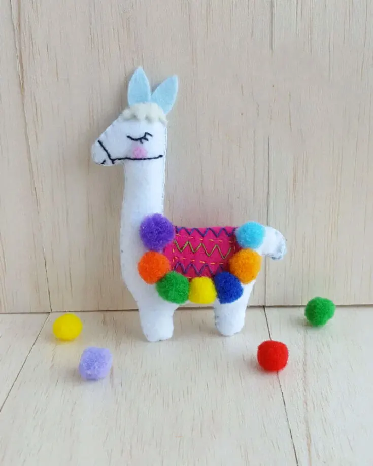 This felt Llama plush is just begging to be your next addition to your stuffed animal zoo. It's colorful, sweet and simple to make with just a few materials that you can find lying around your house, what more can you ask for? The pompoms are a great touch, adding more color and detail to jazz up this fun llama.