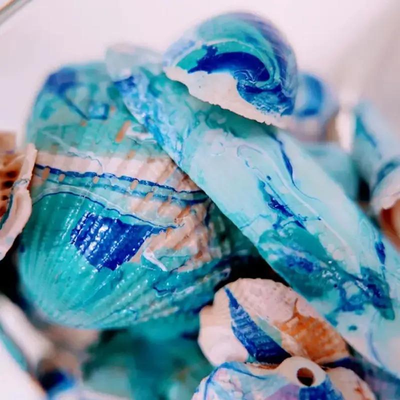 Try painting seashells with a marbling technique using nail polish for a fun and creative family activity! The results are super cool and add a unique twist to your seashell collection. It's a craft everyone can enjoy together!