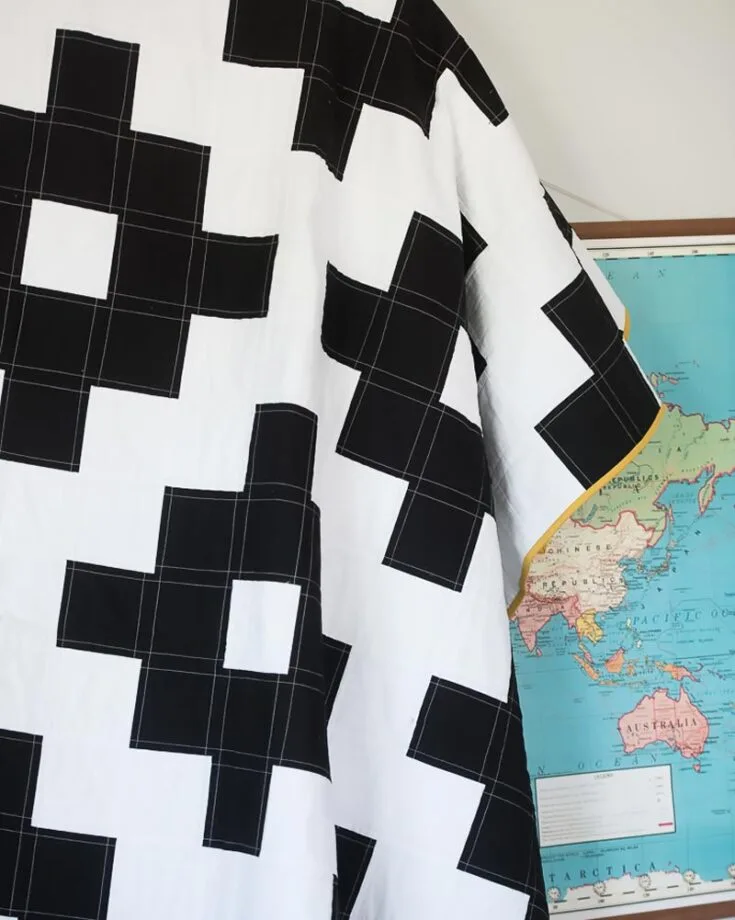Learn to quilt this easy and straightforward Mods Charm Quilt! It&rsquo;s so chic and combines modern aesthetics in a traditional quilt, featuring square blocks of white and black colors to create a retro quilt design. You can use solid colors or your favorite prints, keeping two tones of different colors to create a contrasting look. Sign up for the newsletter to get free access to the PDF guide.