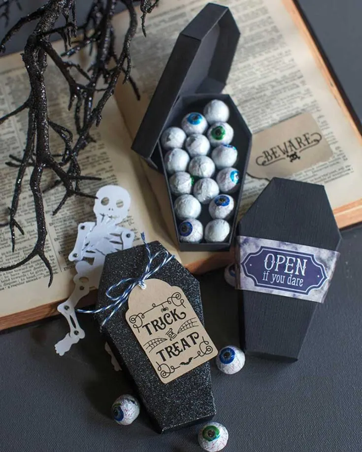 This DIY paper coffin is easy to create using either matte black or metallic paper. The downloadable pattern is a PDF template for those who prefer to cut by hand with scissors or a craft knife. It's perfect for storing wrapped eyeball candies inside!