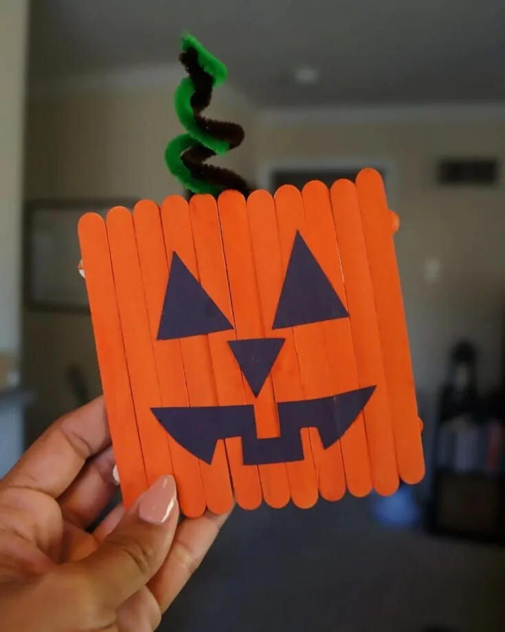 Check out this super cute and easy Jack O&rsquo; Lantern popsicle stick project! It&rsquo;s the perfect kids&rsquo; craft for your little ones to try, and top it off with some green and brown pipe cleaners for the stem.