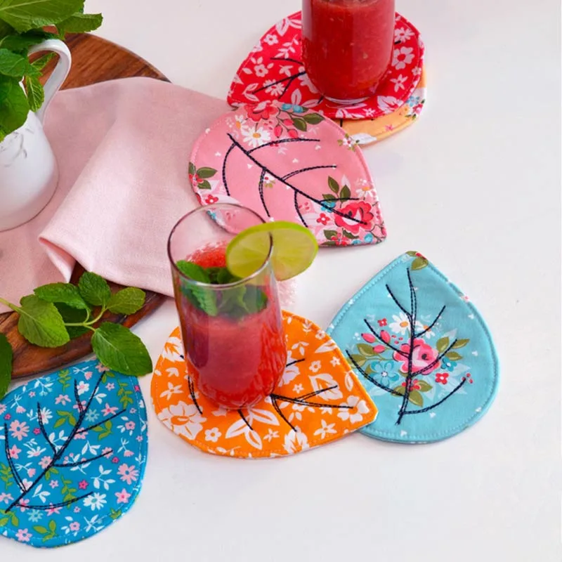 Get into the cozy fall spirit with these quilted leaf coasters, which are ideal for sipping warm drinks while enjoying the gentle fall of leaves from trees. It's the perfect project for keeping your hands busy during a snug night.