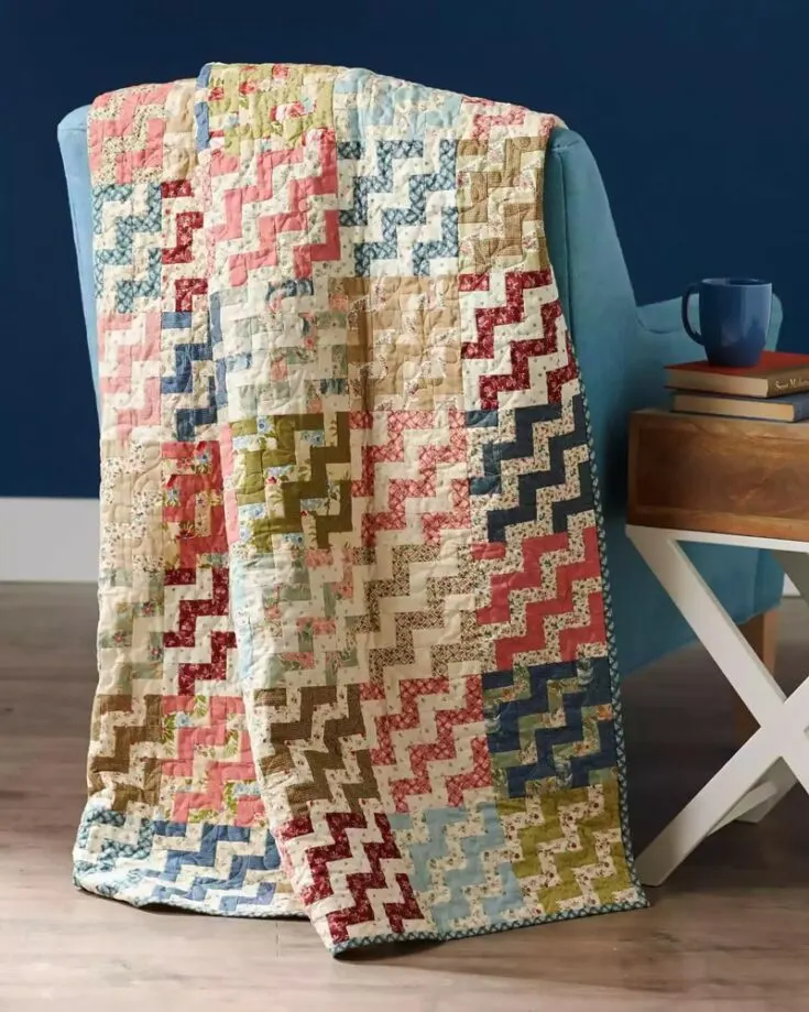 Say hello to the Rail Fence Ripple quilt! This gorgeous ripple-wave effect quilt measures approximately 54 &frac12;" x 72 &frac12;", and the finished block size is 6" squares. It's such a magnificent project, featuring floral prints and colorful strip sets. Learn how to make it by clicking the link below.