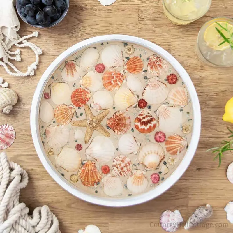 Turn seashells you collected over the summer into a DIY beach tray to serve your guests&rsquo; refreshments on! This easy summer craft turns your beach finds into a charming serving tray with just a few simple steps and resin.