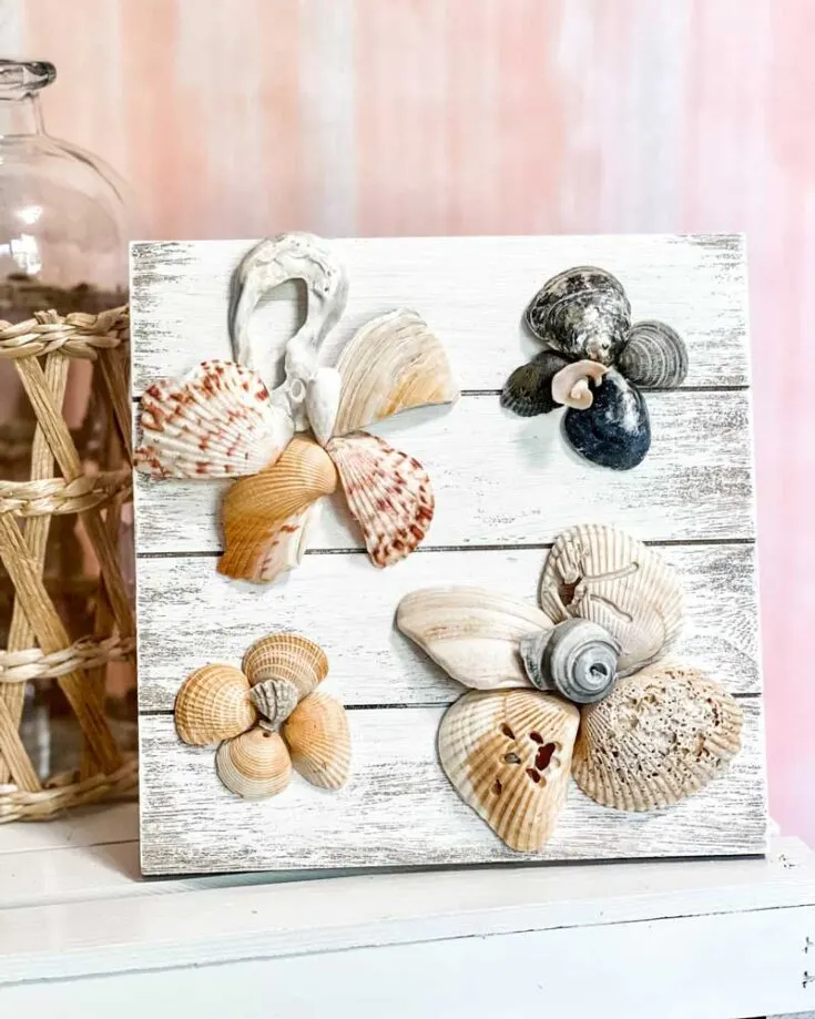 This seashell flower art decor is a great way to decorate and showcase memories from your beach trips in a creative way. Add a coat of chalk paint to a wooden board for a vintage touch, arrange your seashells of different shapes, sizes, and colors into beautiful flower designs.