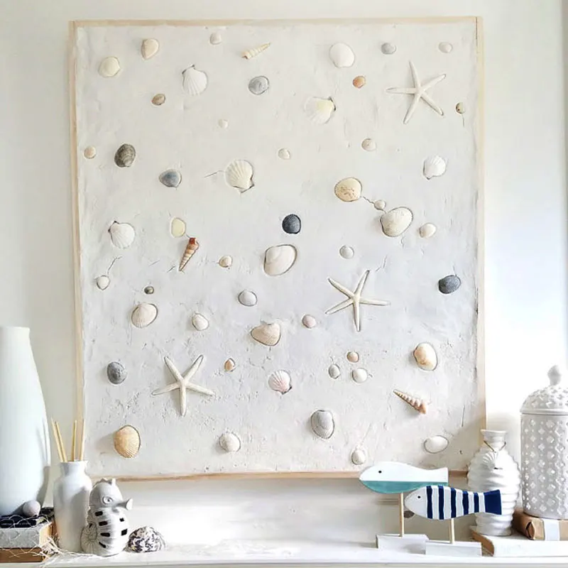Create a summer mantel with a touch of coastal charm by plastering over a frame and embedding seashells before it dries. This simple yet stylish project adds a beachy vibe to your decor, perfect for capturing that summer feeling all year round whenever you look above your fireplace!
