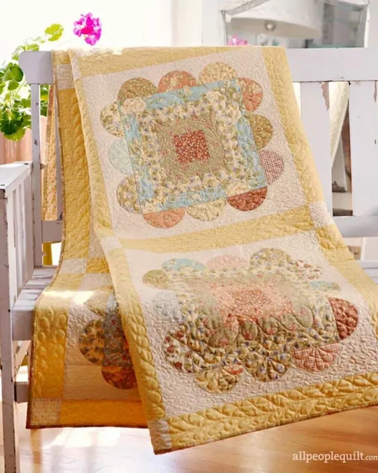 Since Summer is around the corner, quilt up this easy scallops cabin quilt design. Full of vibrancy due to the summery color palette, it&rsquo;ll surely liven up any room in your house. The blocks are also surrounded by appliqu&eacute;d scallops, adding a gentler and more feminine appearance. The finished size is 64 &frac12;&rdquo; x 64 &frac12;&rdquo; square.