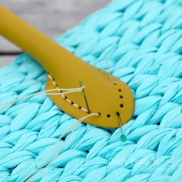 stitch the rolled leather handles to the straw bag through the pre-made holes.