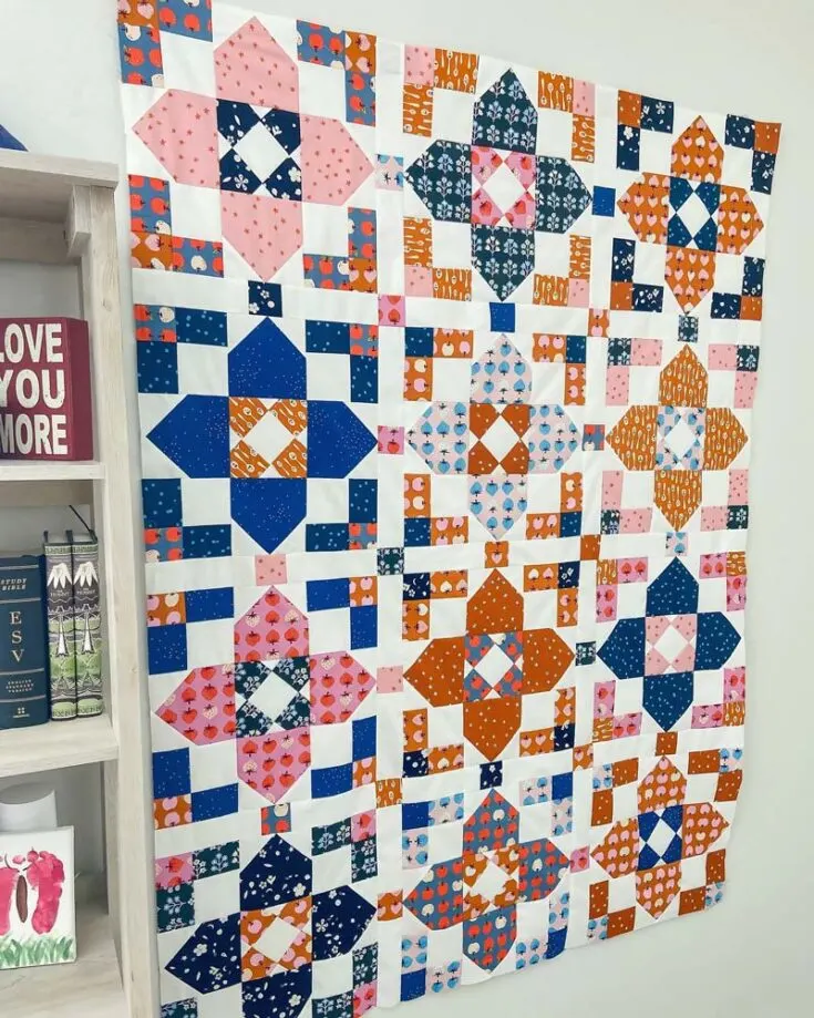 This gorgeous, elegant, and stunning piece is called the Squarevoiyant Quilt! It's an inexpensive pattern made for confident beginners, and it has instructions for four quilt sizes to choose from. The only skill you'll need to make this piece is to utilize snowballing corners and trim your fabric on an angle. Otherwise, it's a relatively simple design with straightforward construction.