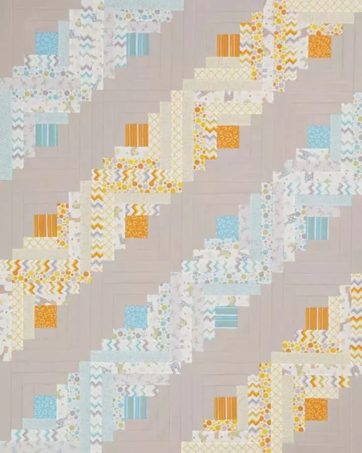 Similar to the harvest table pattern, this one also uses the straight furrows setting. With its playful arrangement of log cabin blocks and a cheerful color palette like bright orange and aqua prints, this quilt will surely bring warmth to any space. The finished size is 48 &frac12;&rdquo; x 60 &frac12;&rdquo;.